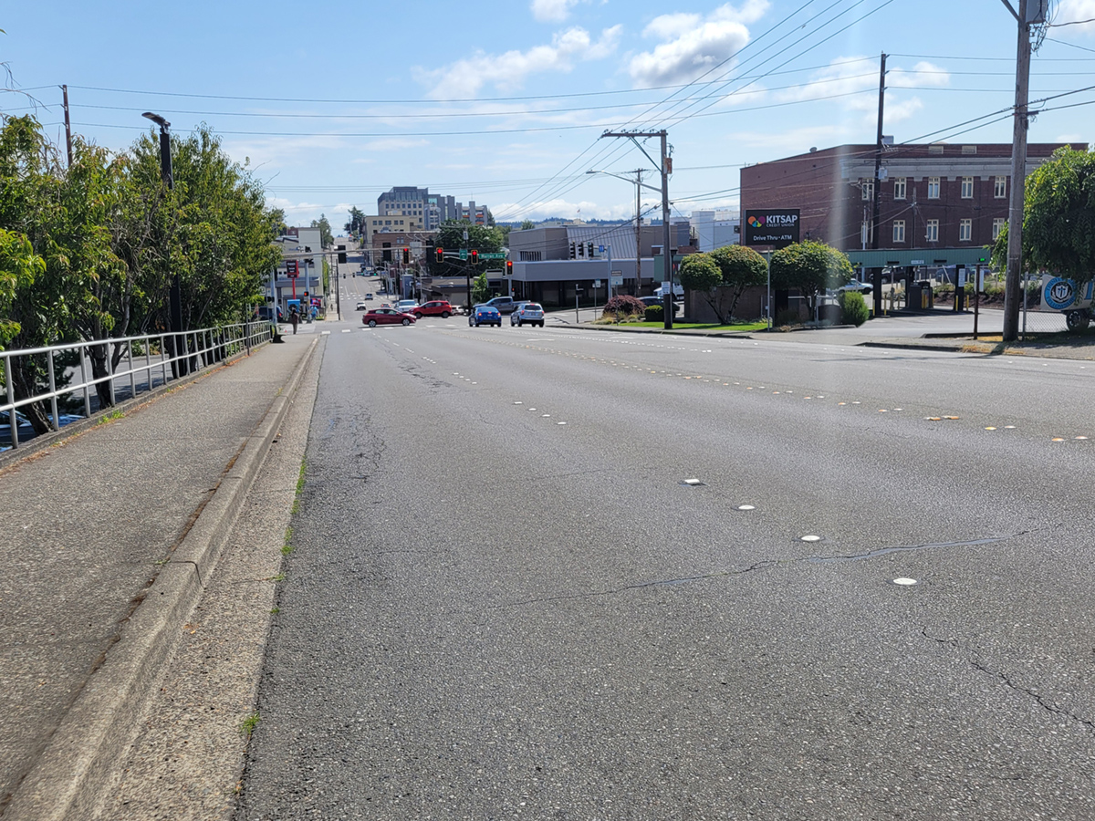 Image of 6th Street roadway with sidewalks on each side. This perspective provides a good representation of the width of the road.