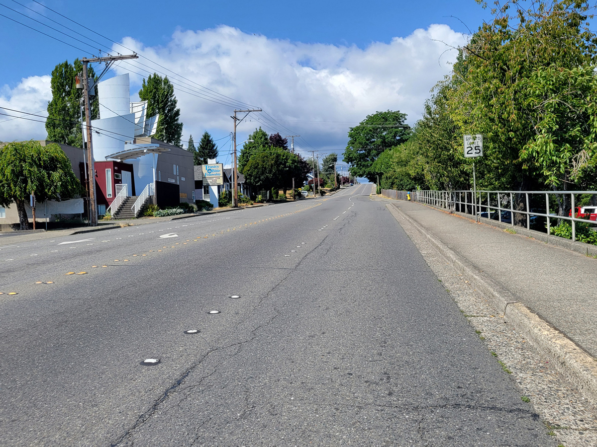 Image of 6th Street roadway with sidewalks on each side. This perspective provides a good representation of the width of the road.